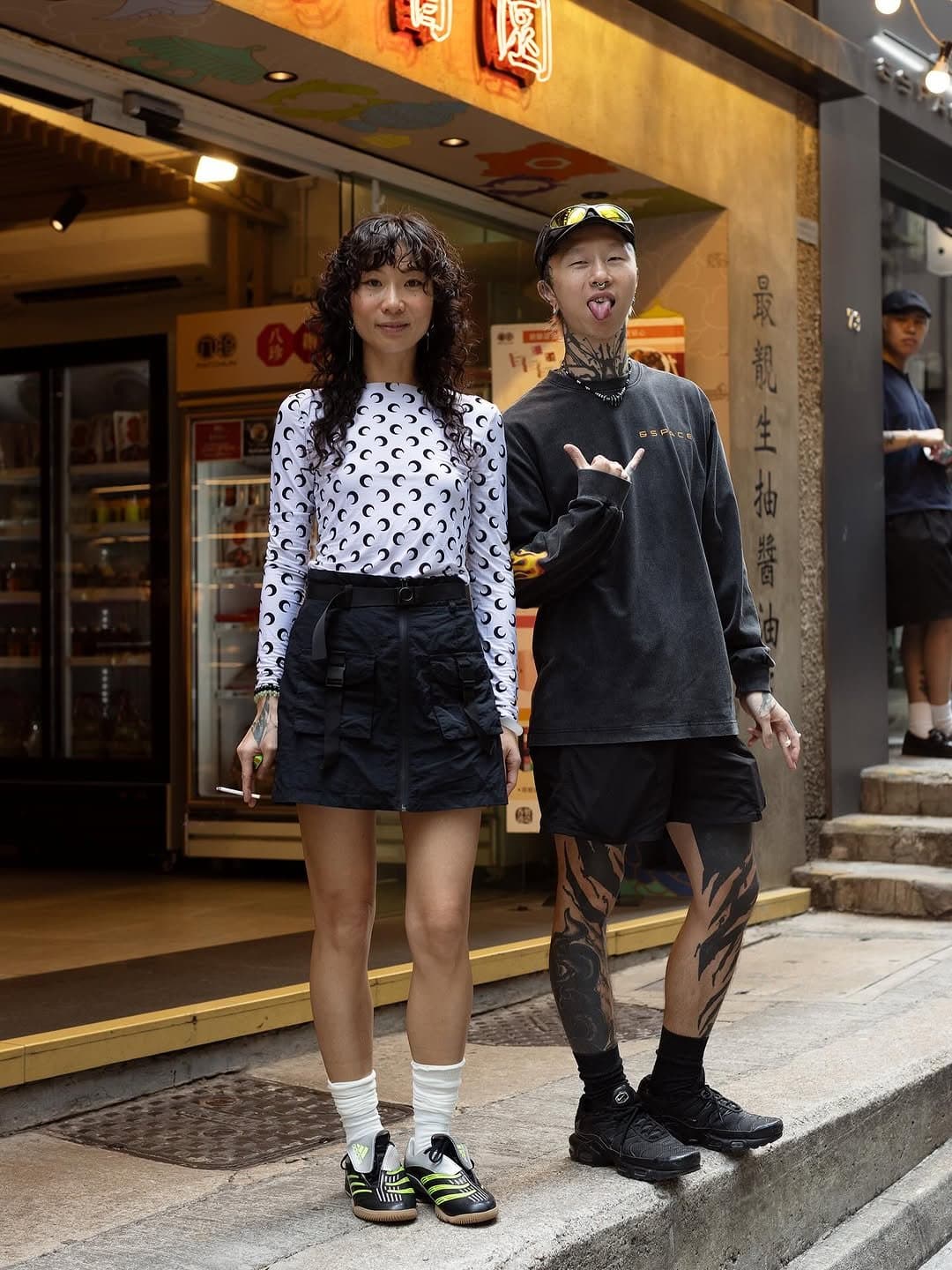 Two street-style looks pair graphic black-and-white separates with sporty footwear and dark utility pieces.