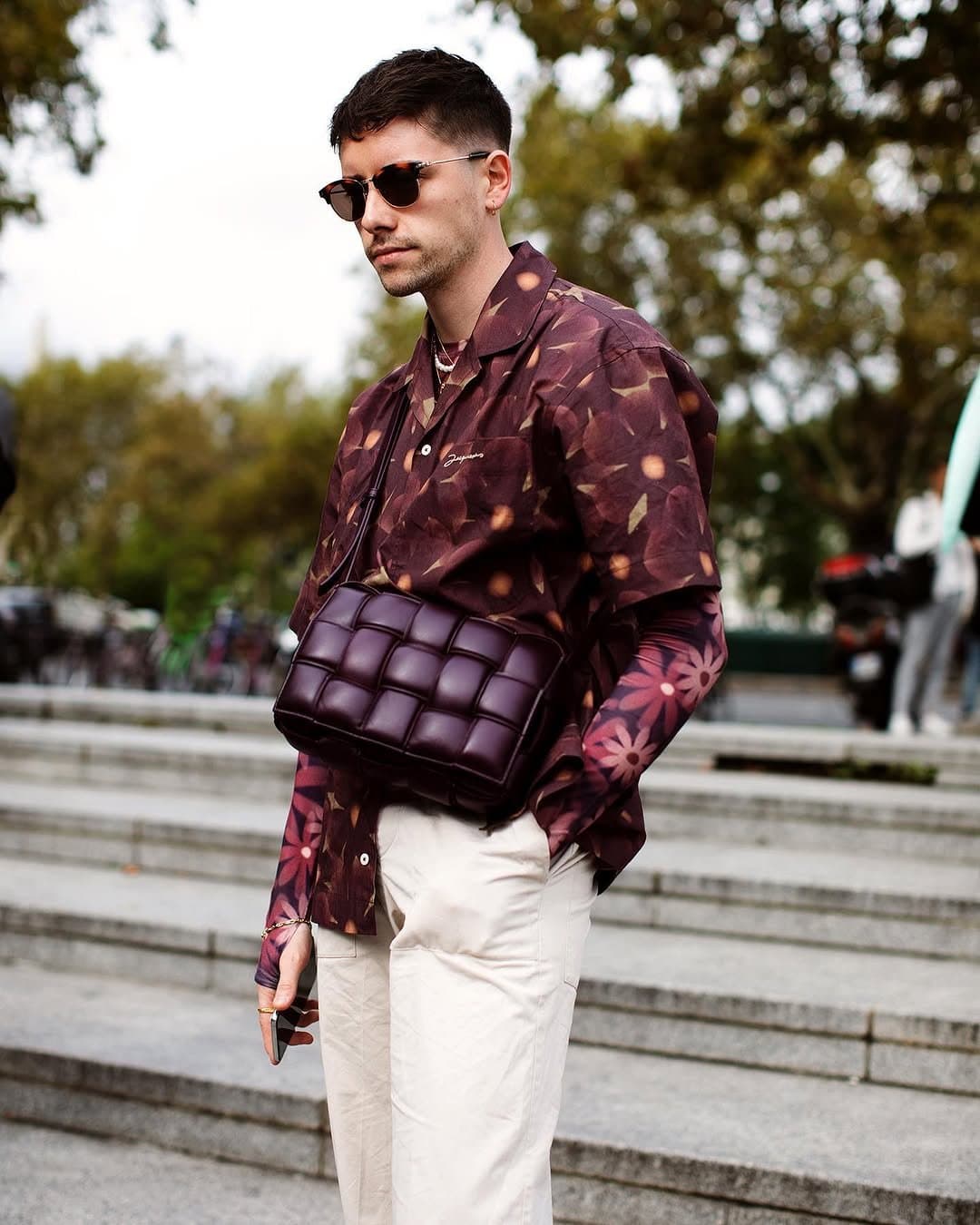 That padded burgundy bag
Drags florals to the street.
