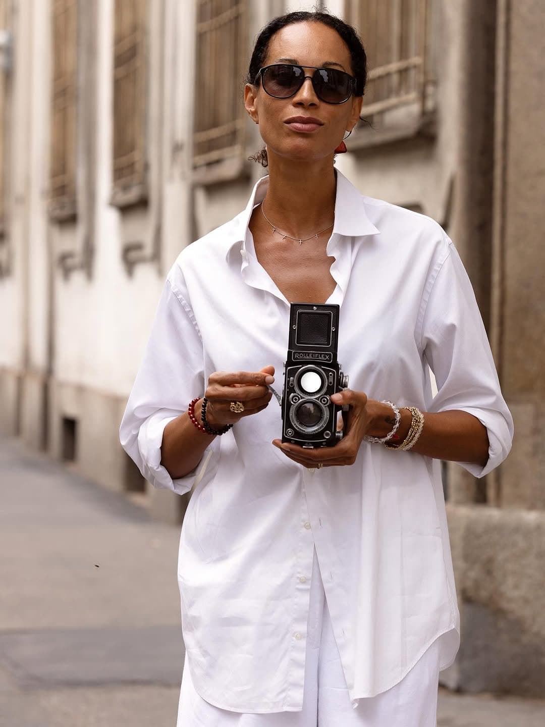 That white shirt performs ease,
then the bracelets confess effort.