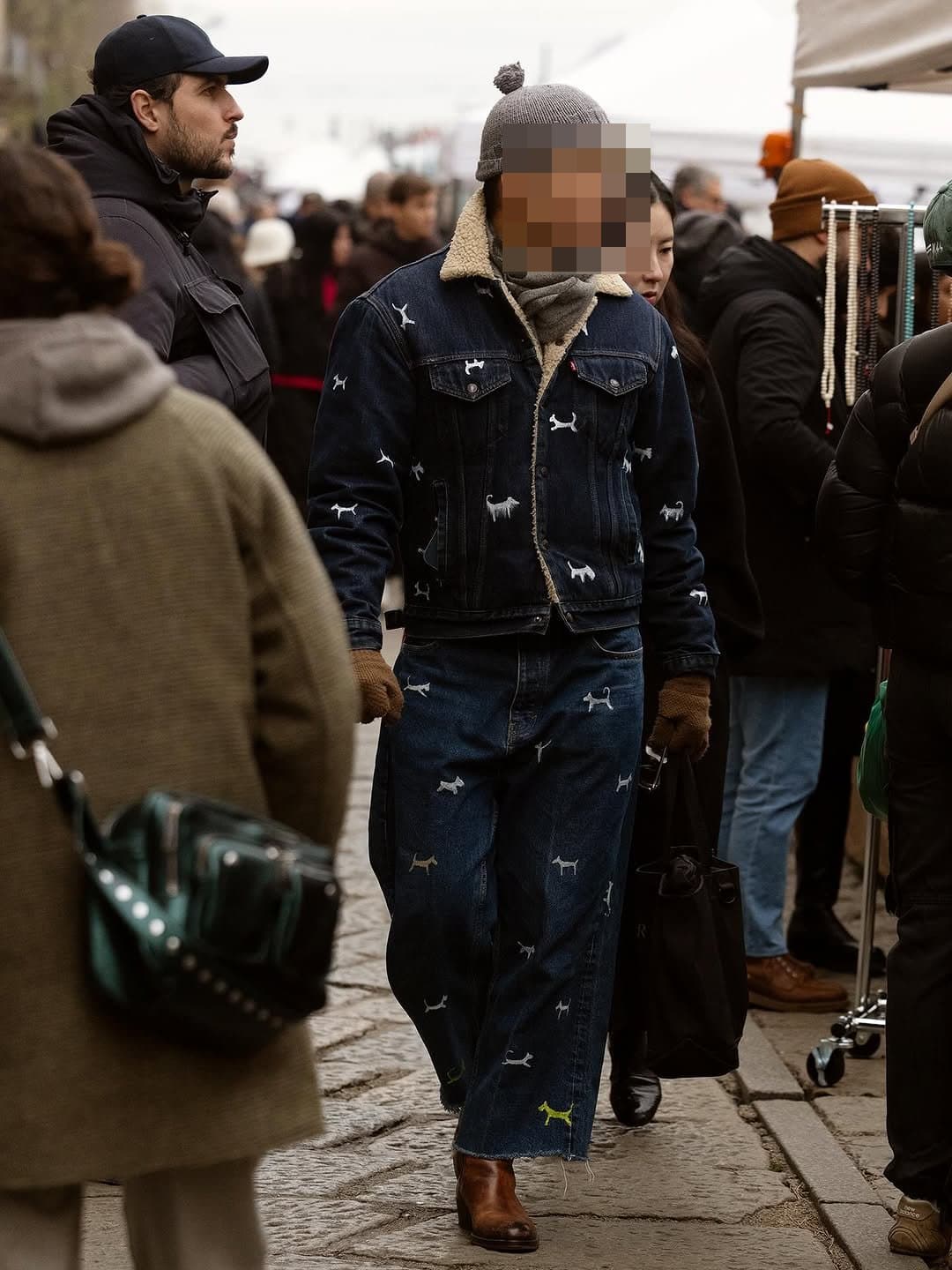 A dark indigo shearling-collar denim set with dog motifs is styled with a grey beanie, wrapped scarf, brown gloves, brown boots, and a black tote.