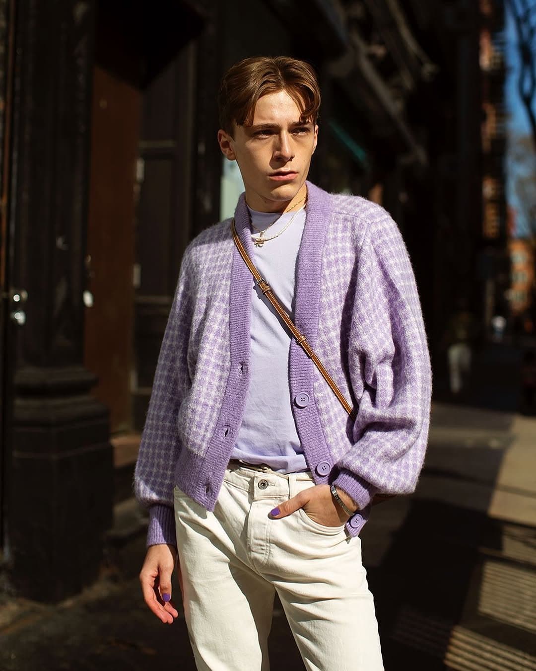 A lavender checked fuzzy cardigan over a pale tee with cream jeans, gold necklaces, and a brown crossbody strap.